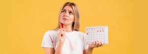Mujer dubitativa con un calendario menstrual